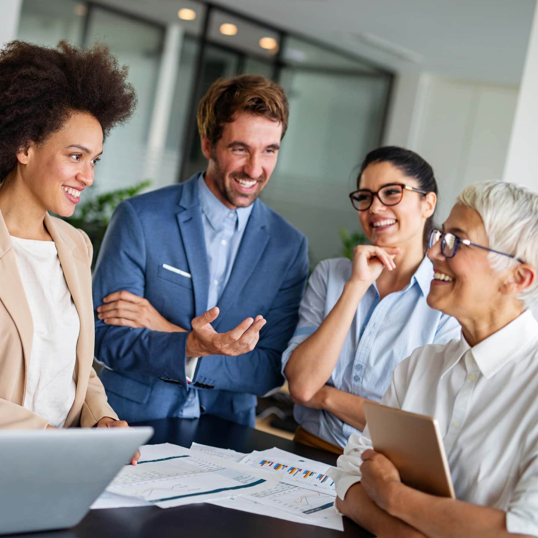 Happy team of business professionals in a modern office setting.